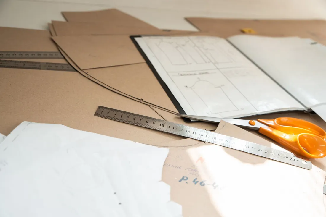 Paper patterns, rulers and scissors on a cutting table