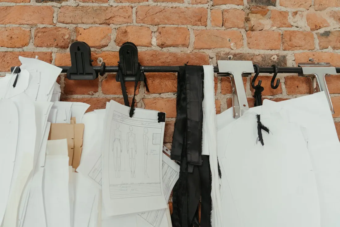 Sewing patterns and fabric hanging on a brick wall