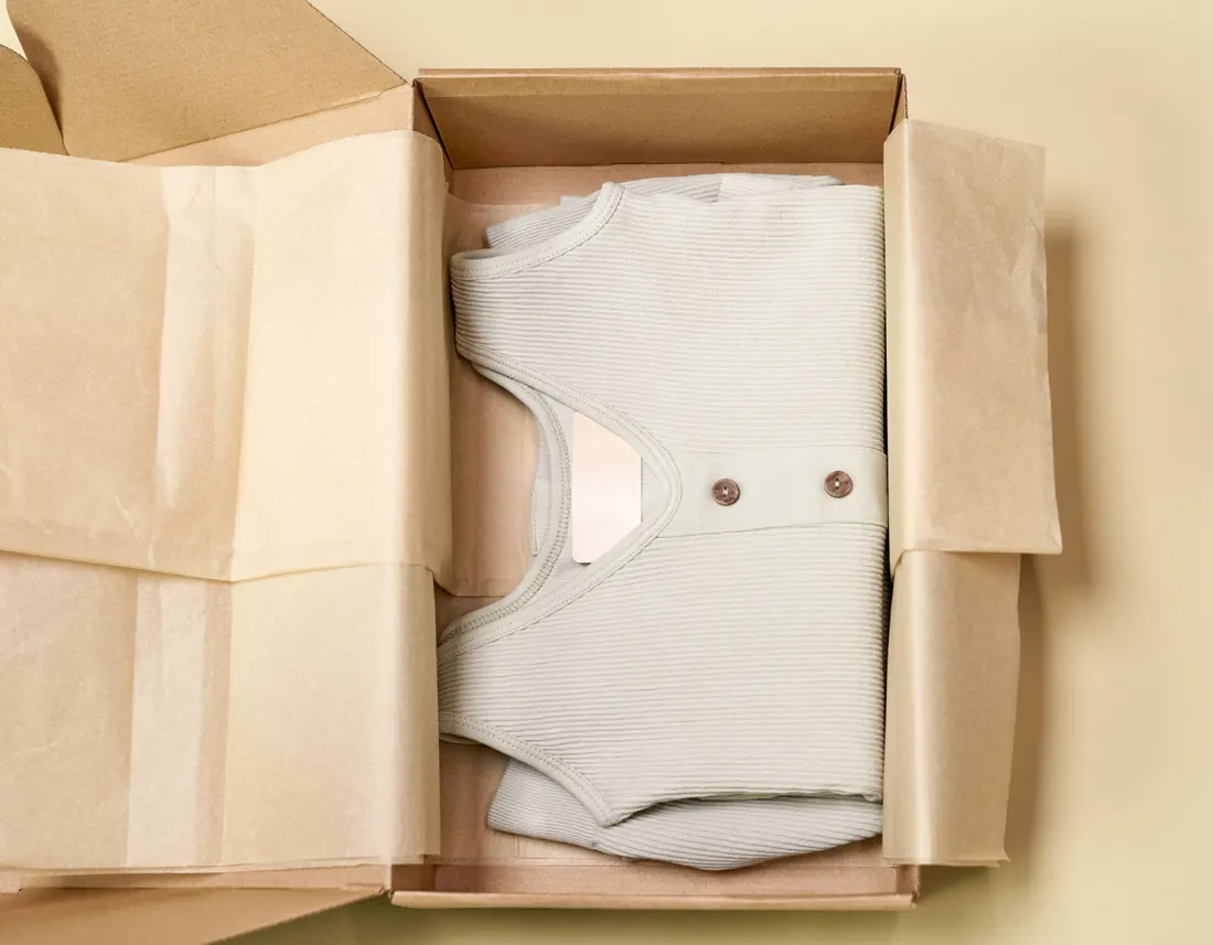 A folded garment packed in a cardboard box