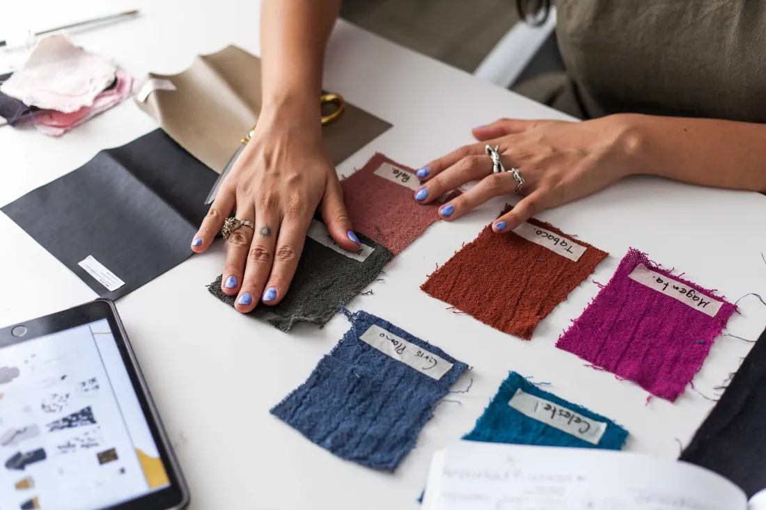 Hands going through fabric swatches